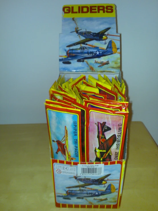 an assortment of toys sit in a cardboard package on a table