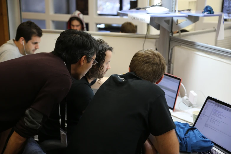 a group of people using two laptop computers