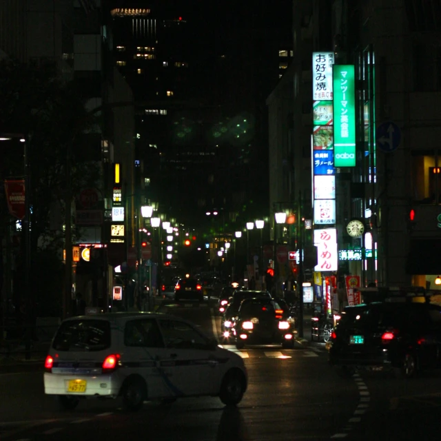 a busy city street at night filled with traffic