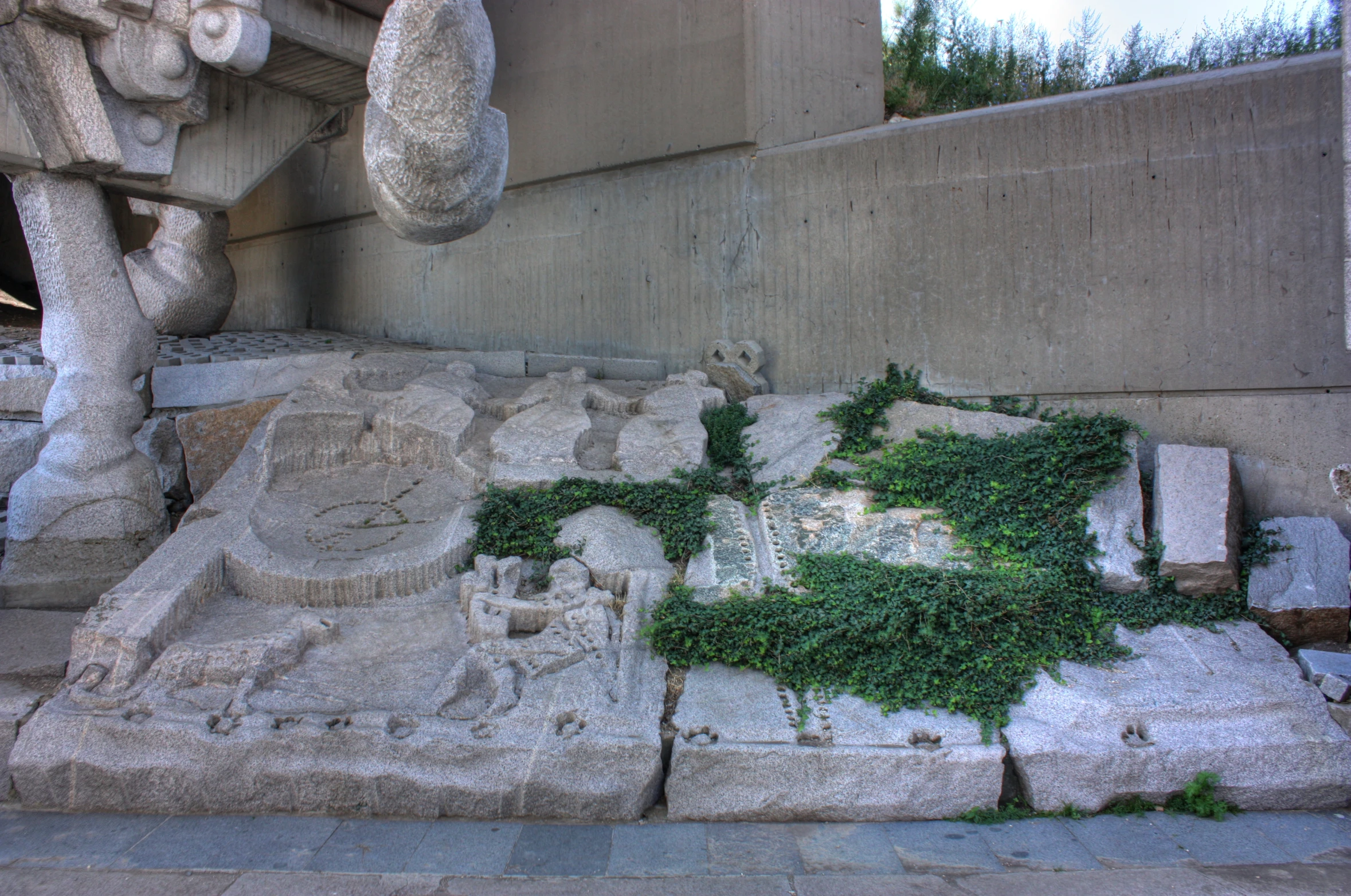 many sculptures and sculptures with vines growing on them