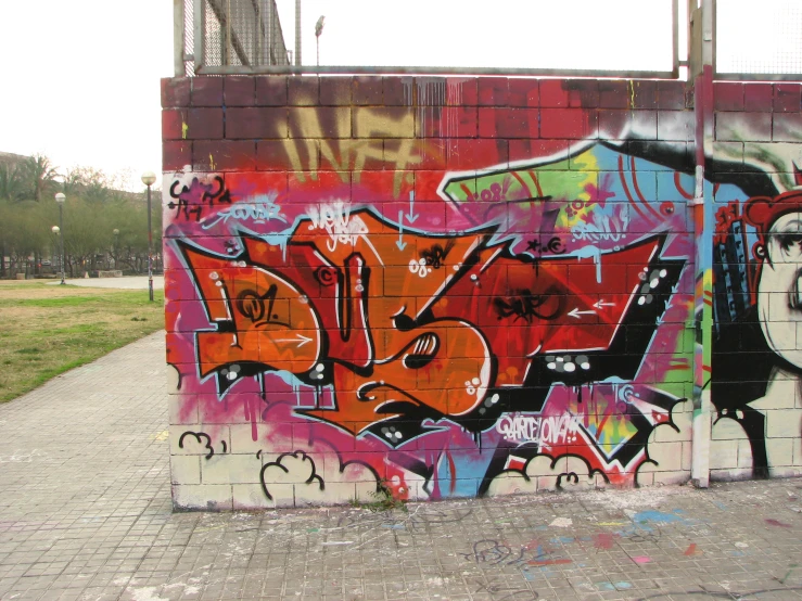an urban wall has colorful graffiti on it