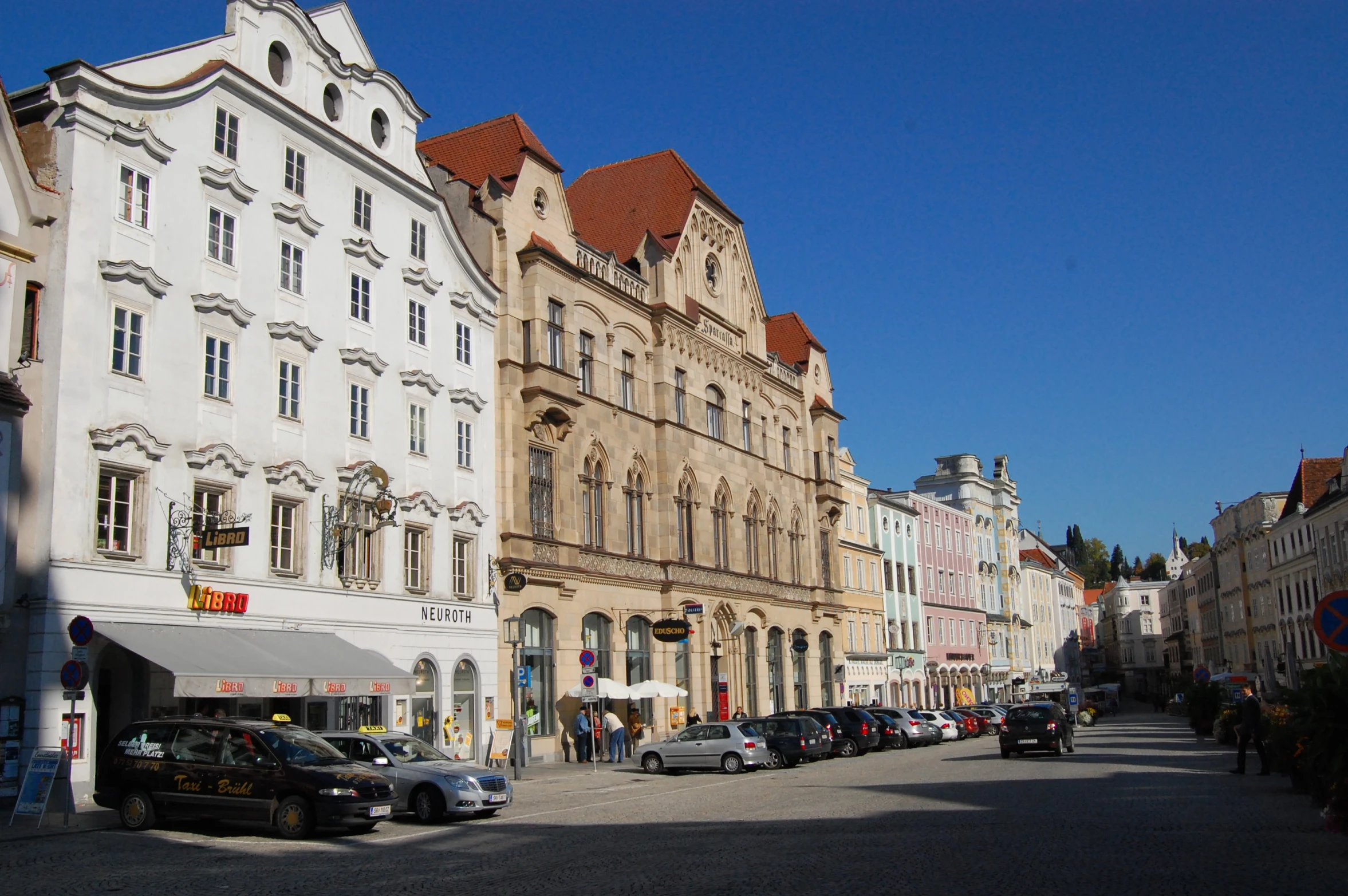 several parked cars sit in front of some buildings