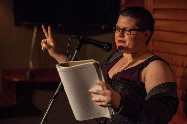 a woman in black dress holding a microphone