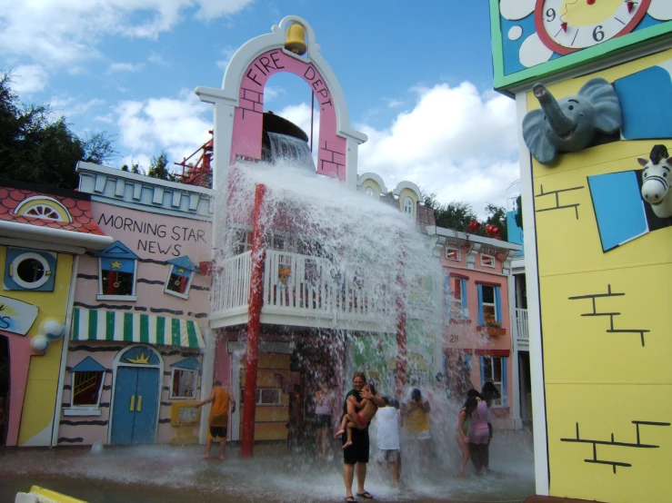 a large fountain is spouting with water and people are gathered outside