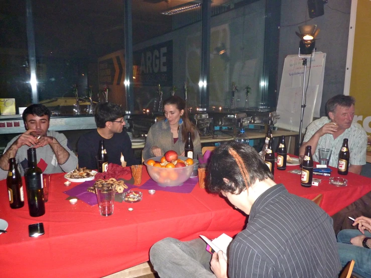 a group of young people seated at a table drinking
