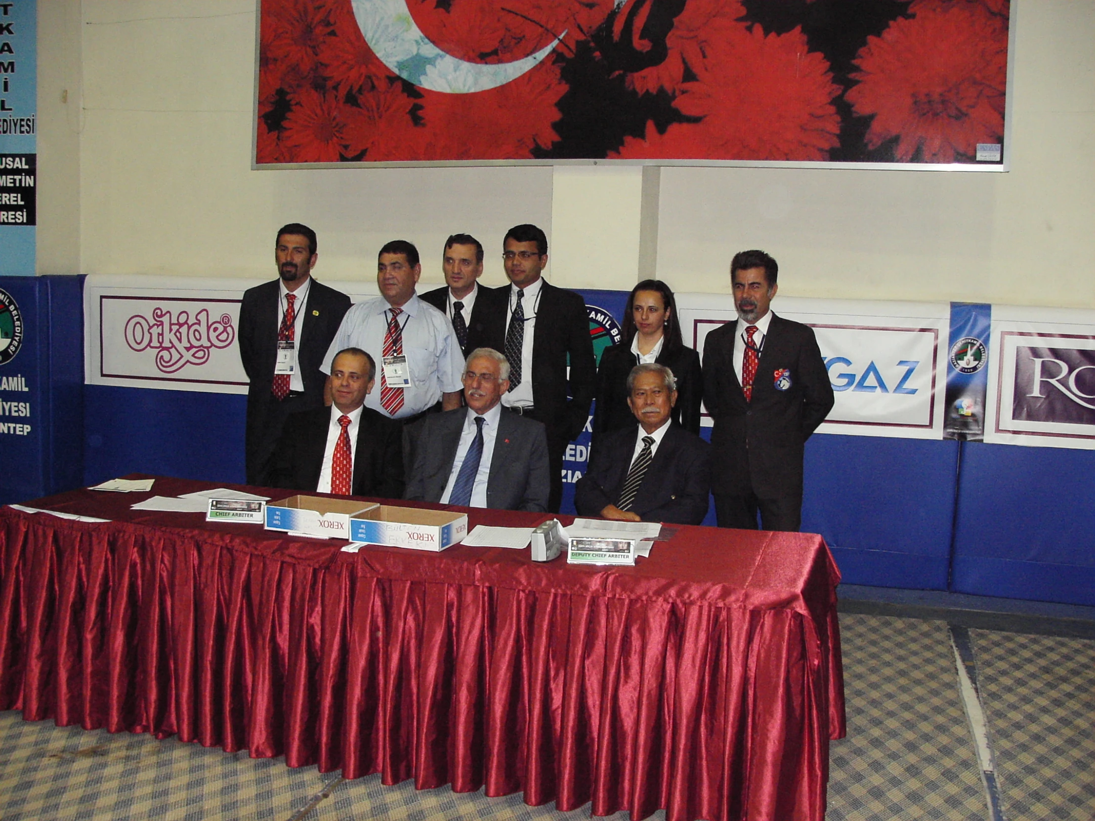 people posing for a po in front of a table covered with papers