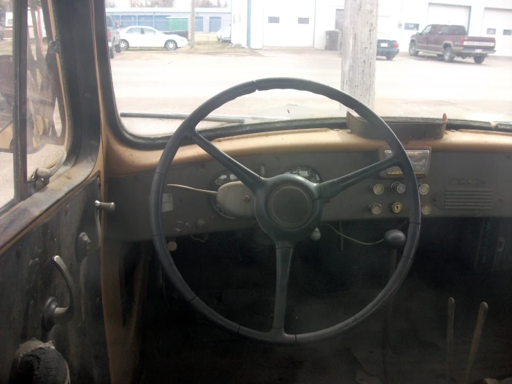 an old car in a garage filled with junk