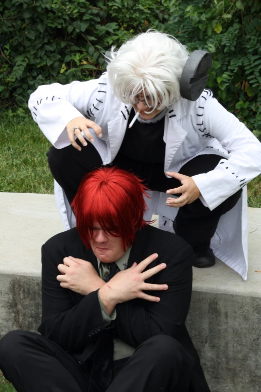 a couple of people in costume sitting on a concrete wall