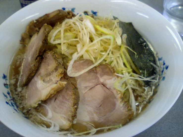 white bowl filled with various foods sitting on top of a table