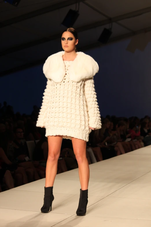 a woman in a white dress standing next to a woman with a fur coat