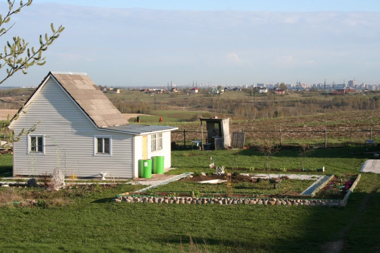 a small white house sits on an open field