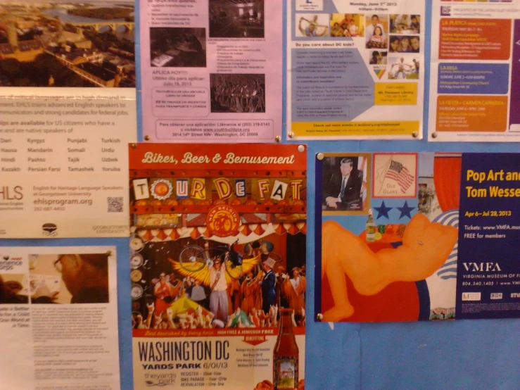 several brochures displayed against a wall with images on it