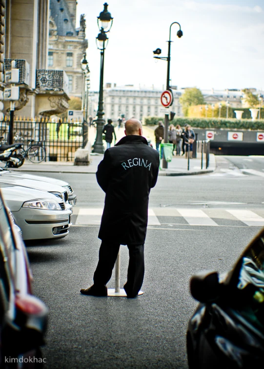 a man in a jacket standing at a traffic light