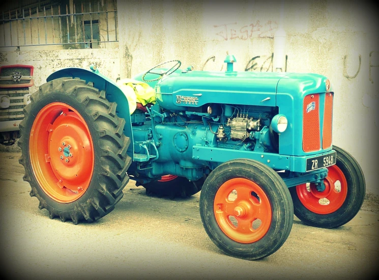 an old farmall parked outside a building on a gravel lot
