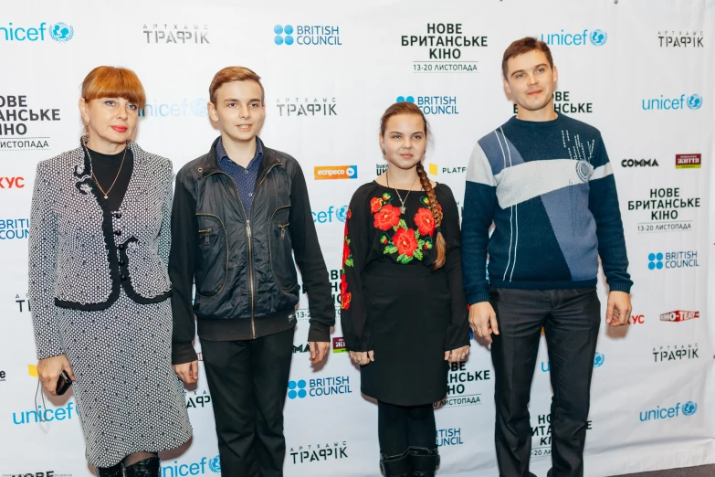 three people are standing together on the red carpet