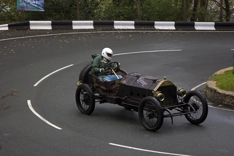 an old model t car driving down a curvy road