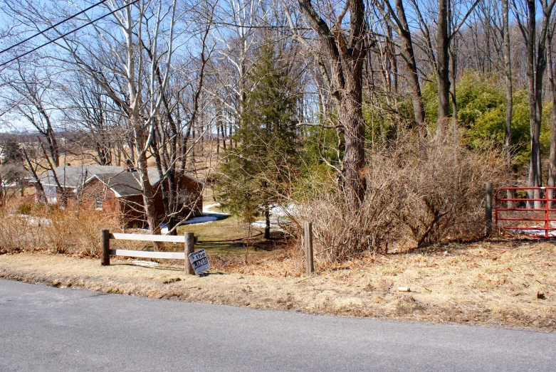 a farm with trees and a gated area in front