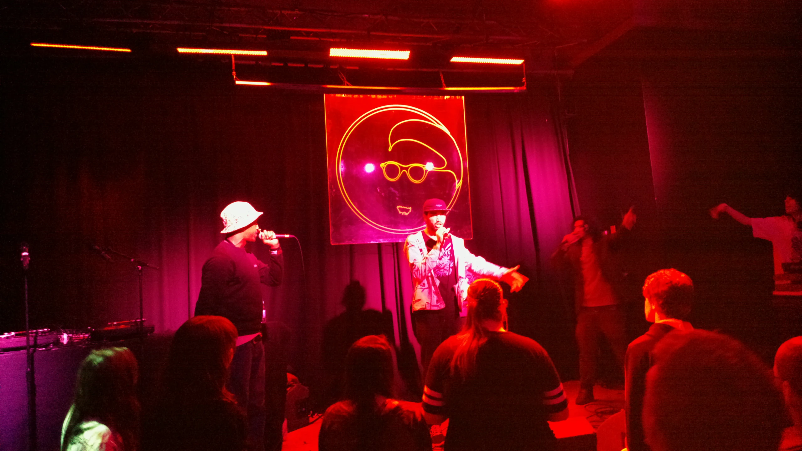 a group of people in a dark room with speakers