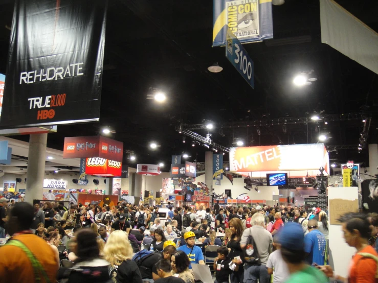 a crowd of people are in an indoor convention center