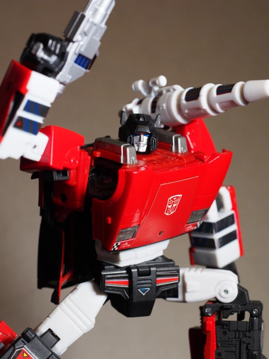 a red and white toy robot with large arms