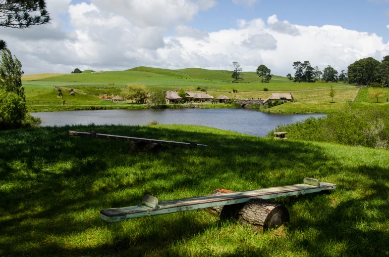 a wooden bench sitting on a lush green field