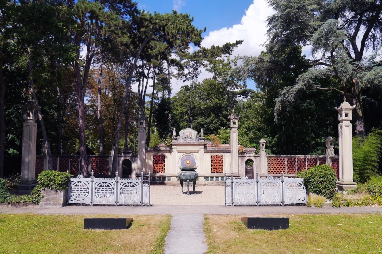 a park with trees and an iron fence