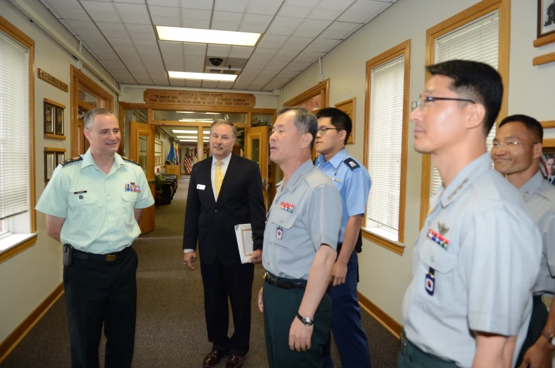 two men are speaking to other uniformed men in uniform