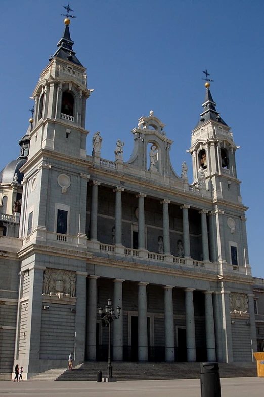 two tall clock towers with spires on a building