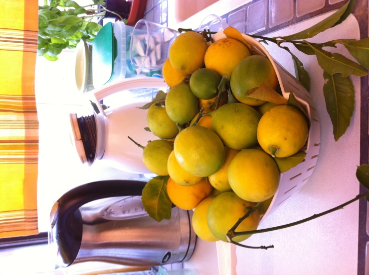 a bowl filled with lemons on top of a table