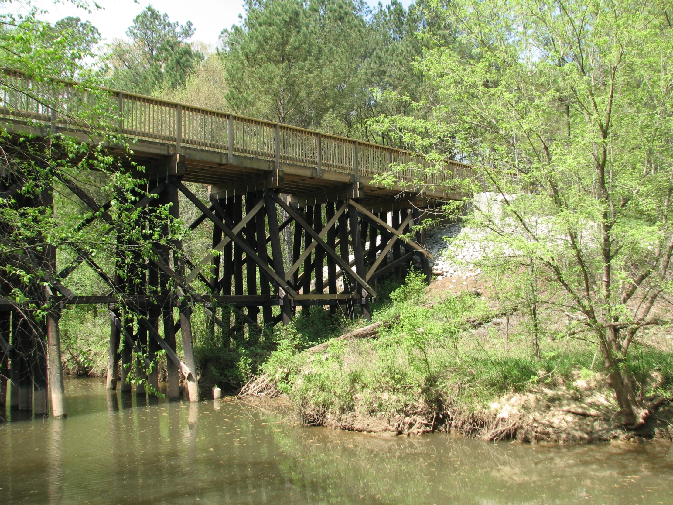 a bridge crosses over water with trees in the background