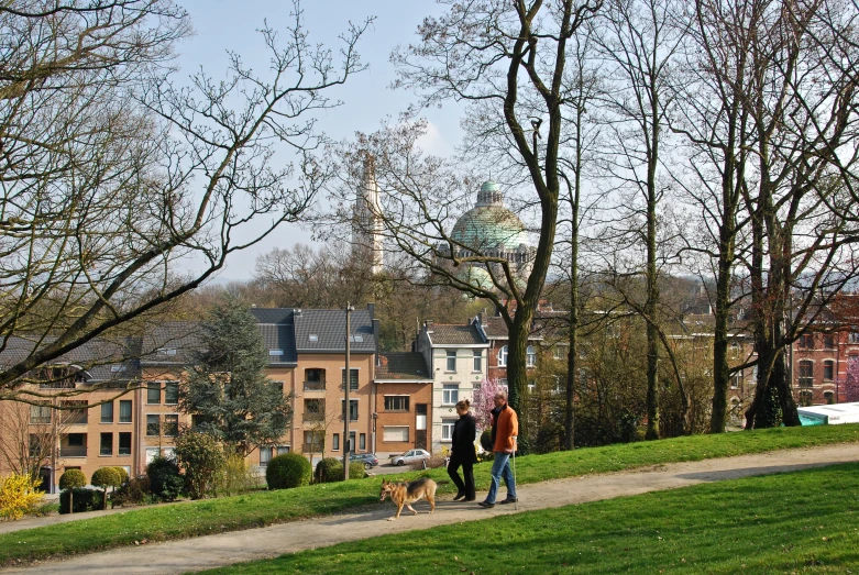 a woman walks down the path next to her dog