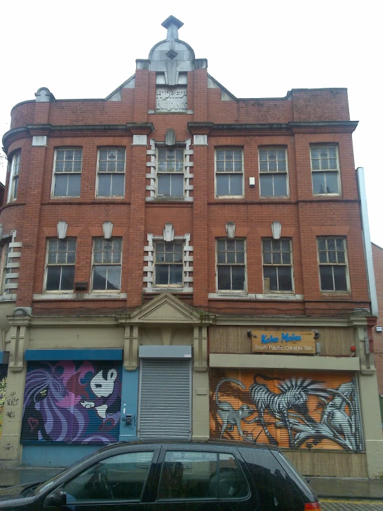 a car parked in front of a building with graffiti