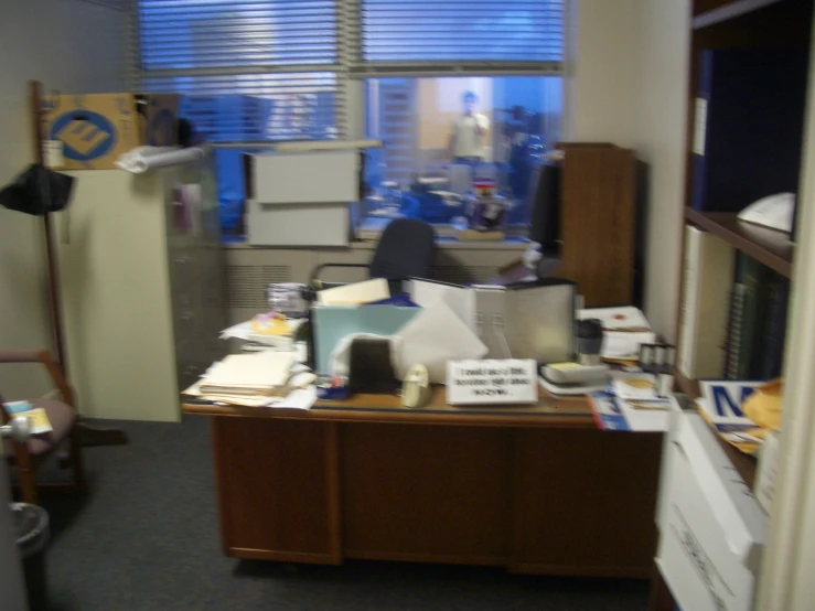 a cluttered desk with files and computer equipment