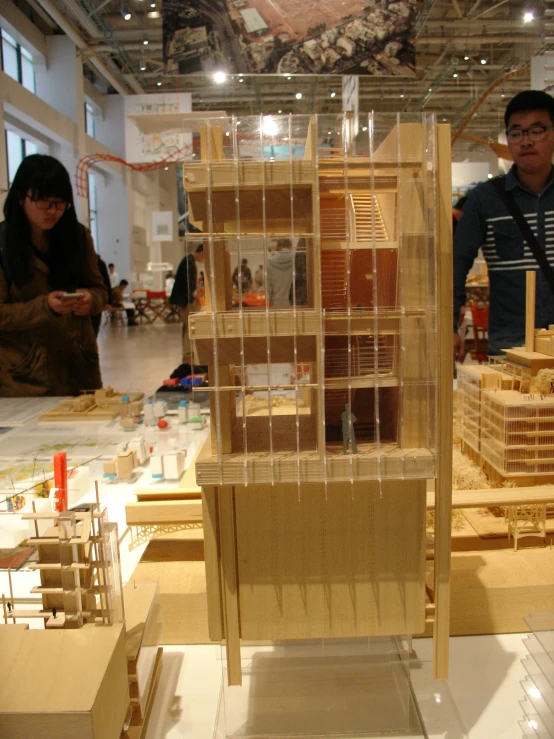 a man and woman are observing a model of a building