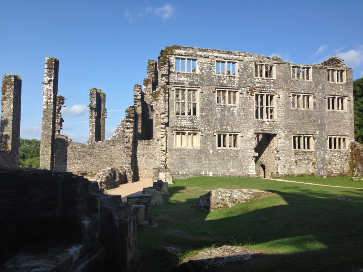 an old castle building with many windows and a green lawn