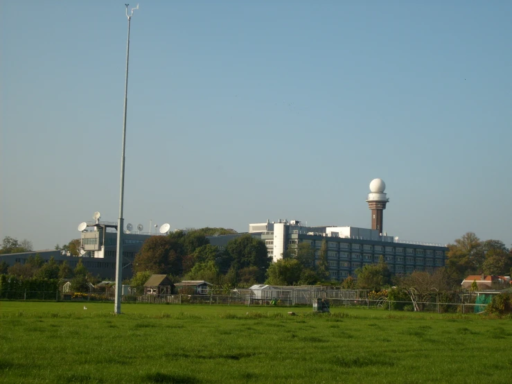 a field that has a building with two radio towers