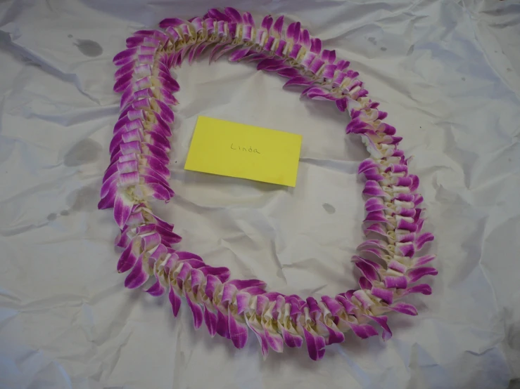 the purple flower lei with a yellow tag has two loops