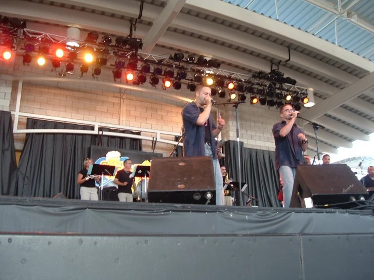 two men on stage in front of a microphone