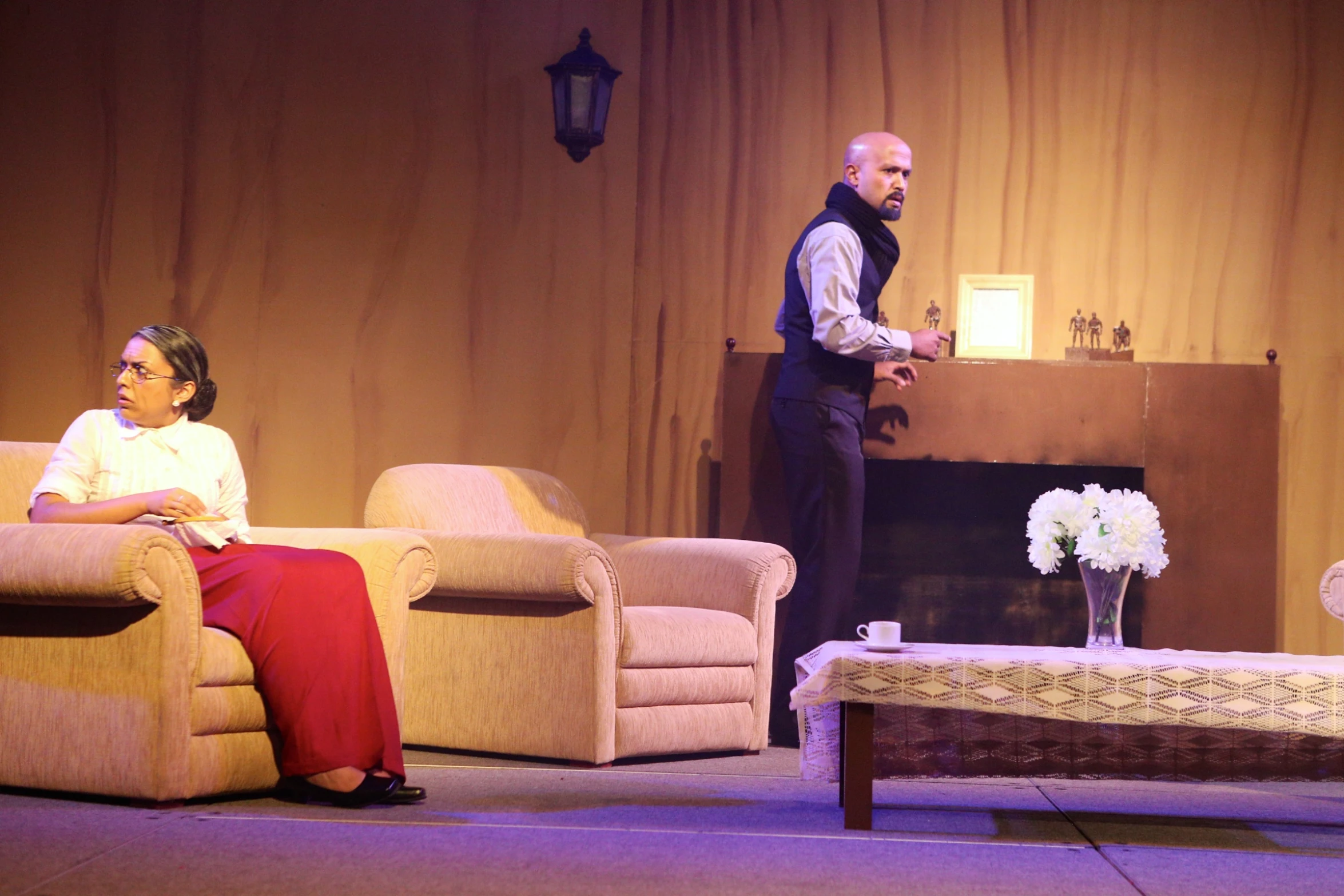 two women and a man on stage with a coffee table