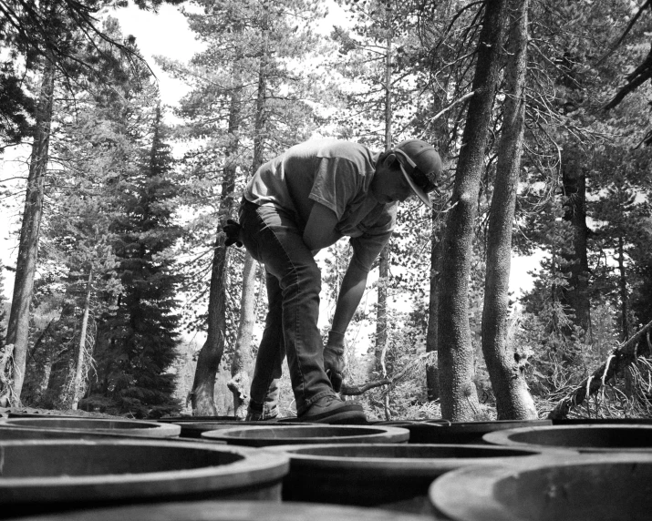 a man standing in the middle of a forest with a hat on