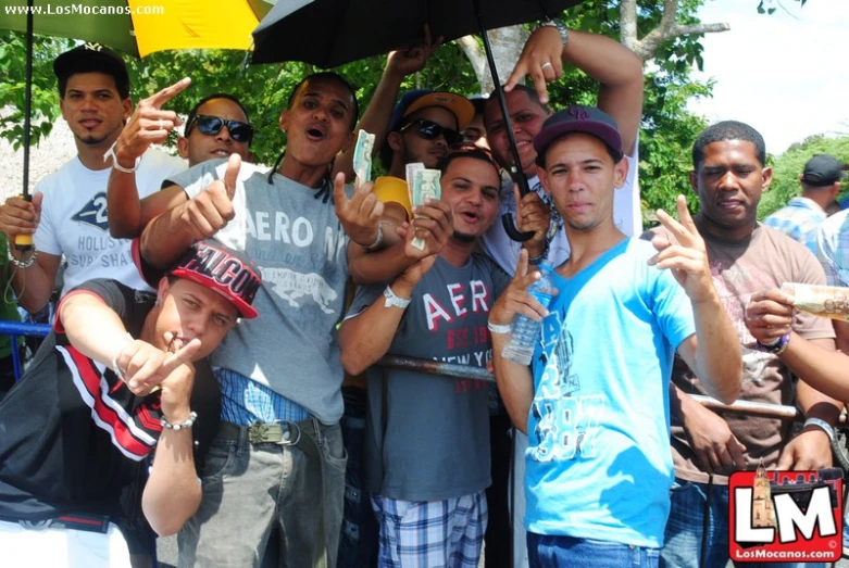 a group of men stand together with an umbrella