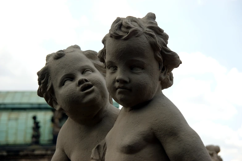 two small statues of s are next to a building