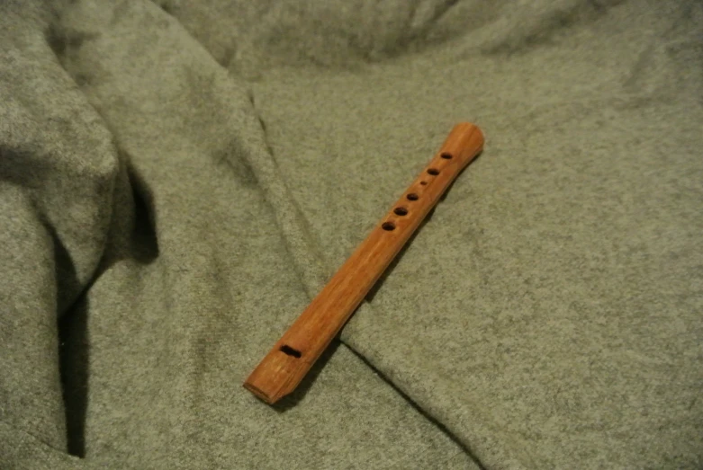 a recorder laying on the sheets of a bed