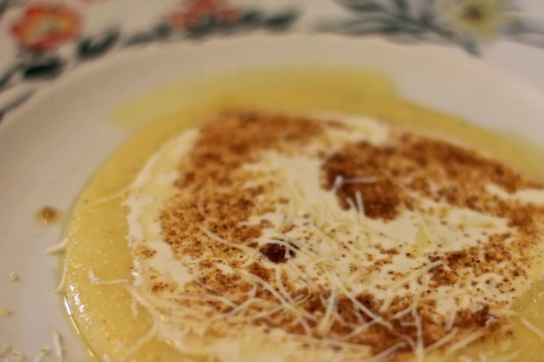 a creme and some other powdered toppings on top of a white plate