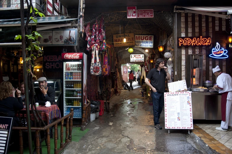 a man walking through a restaurant with a menu board