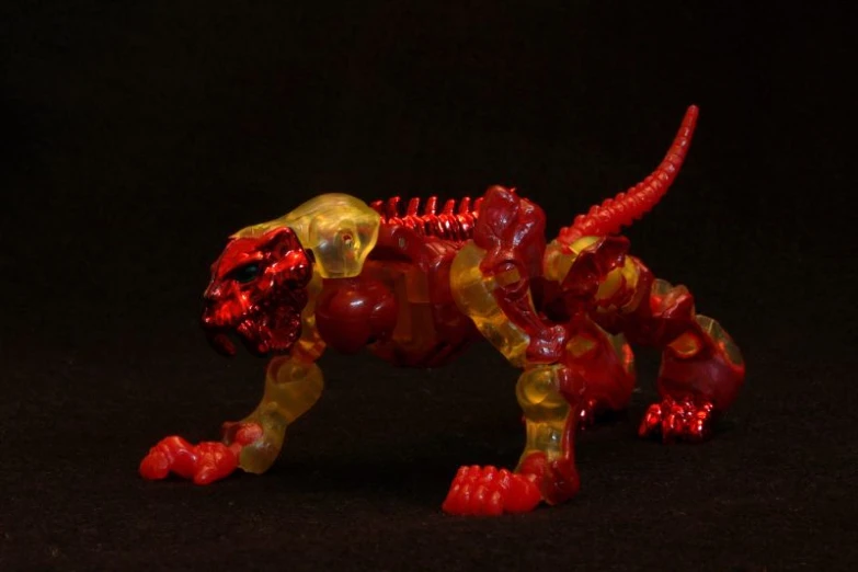 there is a small plastic lion that is red and gold