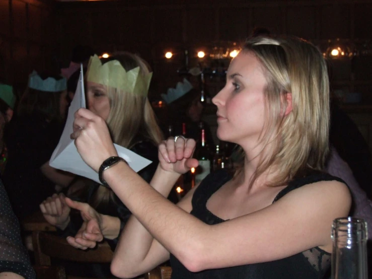 a woman wearing a party hat holding paper