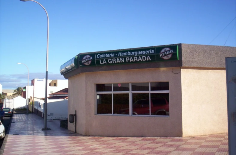 a car sitting in front of a large tan building