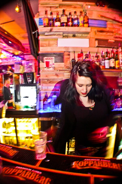 a woman with red hair in a black shirt in front of a bar