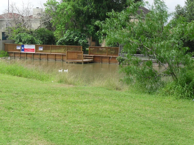 many chairs and a fence sit near a stream